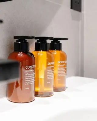 a group of four bottles of soap on a shelf at Stylish studio next to canal in Dubai