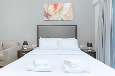 a bedroom with a white bed with two towels on it at Burj Khalifa View I Near to Dubai Mall in Dubai