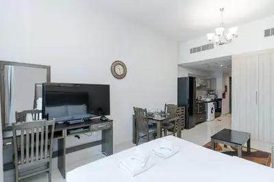 a living room with a television and a table with chairs at Burj Khalifa View I Near to Dubai Mall in Dubai