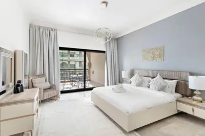 a white bedroom with a large bed and a balcony at StoneTree - Fairmont South 2 BR - Near Beach in Dubai