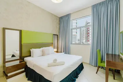 a hotel room with a large bed and a desk at RH-Prime Location , Spacious 1 Bedroom near Mall of the Emirates in Dubai