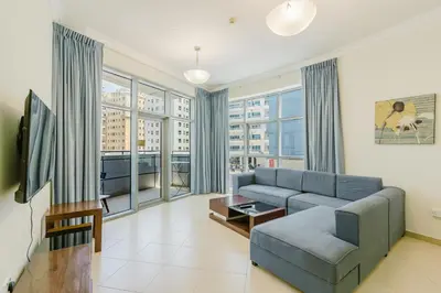 a living room with a couch and a tv at RH-Prime Location , Spacious 1 Bedroom near Mall of the Emirates in Dubai