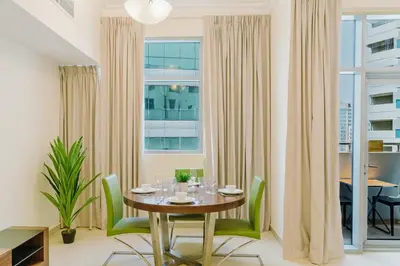 a dining room with a table and chairs and a window at RH- Huge, Comfortable 01 BR Apartment in Barsha1 in Dubai