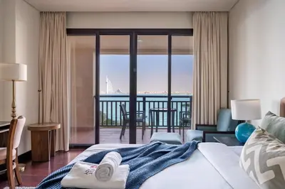 a bedroom with a bed and a view of the ocean at GuestReady - A Glimpse of Burj Al Arab in Dubai