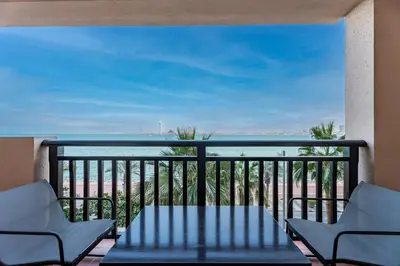 a balcony with two chairs and a table at GuestReady - A Glimpse of Burj Al Arab in Dubai