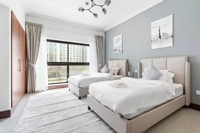 a bedroom with two beds and a large window at StoneTree - Golden Mile 5 2BR - Near Nakhil Mall in Dubai