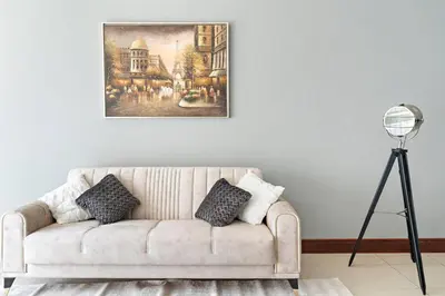a living room with a couch and a painting on the wall at StoneTree - Golden Mile 5 2BR - Near Nakhil Mall in Dubai