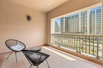 a balcony with two chairs and a large window at StoneTree - Golden Mile 5 2BR - Near Nakhil Mall in Dubai