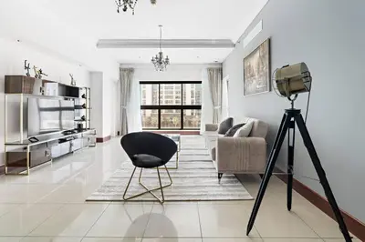 a camera tripod in a living room with a chair at StoneTree - Golden Mile 5 2BR - Near Nakhil Mall in Dubai