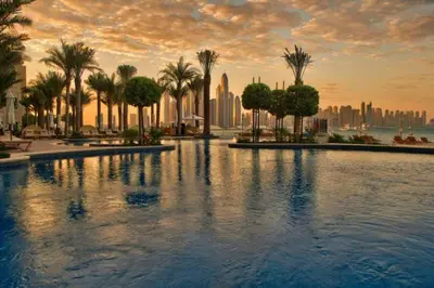 a large swimming pool with palm trees and a city at StoneTree - Golden Mile 4 2 BR - Supreme Residences in Dubai