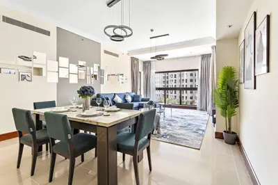 a dining room and living room with a table and chairs at StoneTree - Golden Mile 4 2 BR - Supreme Residences in Dubai