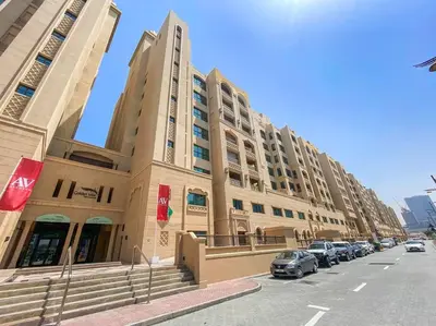 a large building with cars parked in front of it at StoneTree - Golden Mile 4 2 BR - Supreme Residences in Dubai