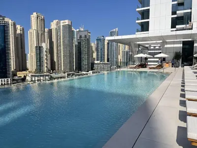 a large swimming pool in a city with tall buildings at BRAND-NEW 1 Bedroom with full Marina View in Dubai