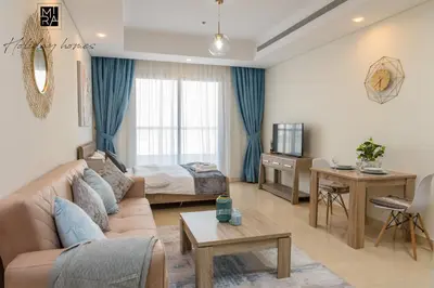 a living room with a couch and a bed at Mira Holiday Homes - Beautiful Studio in Living Legends in Dubai