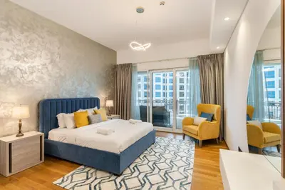 a bedroom with a king sized bed and a living room at Marina Residences 2BR: Seaside in Palm Jumeirah in Dubai
