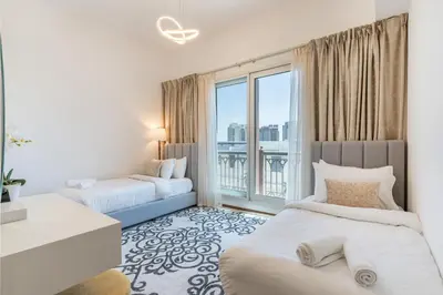 a bedroom with two beds and a large window at Marina Residences 2BR: Seaside in Palm Jumeirah in Dubai