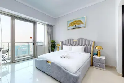 a bedroom with a bed and a large window at Ocean Heights - Gorgeous One Bedroom in Dubai
