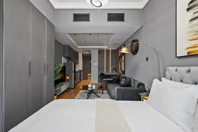 a bedroom with a bed and a living room at Luxury studio at JLT near metro in Dubai