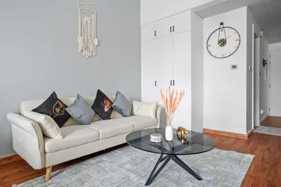 a living room with a couch and a table at Stylish studio at Sports City in Dubai