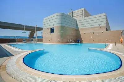 a large swimming pool in front of a building at Stylish studio at Sports City in Dubai