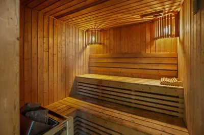 a wooden sauna with a bench in it at Stylish studio at Sports City in Dubai