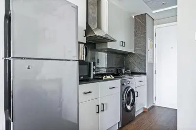 a kitchen with a refrigerator and a washing machine at Upscale studio at JLT near metro in Dubai