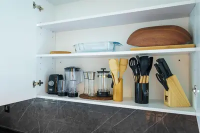 a kitchen shelf with various kitchen utensils on it at Upscale studio at JLT near metro in Dubai