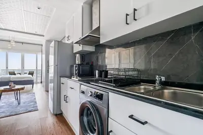 a kitchen with a washing machine and a sink at Upscale studio at JLT near metro in Dubai