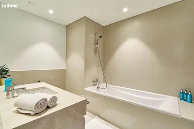 a bathroom with a bath tub and a sink at bnbme - Luxury 1BR Apt w Burj Khalifa Views Pool Gym & Prime Location Near Dubai Mall in Dubai