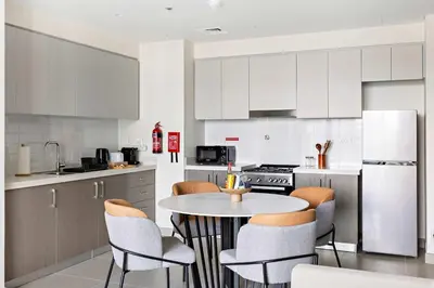 a kitchen with a table and chairs in it at Silkhaus Opera district in Downtown new tower with pool & gym in Dubai