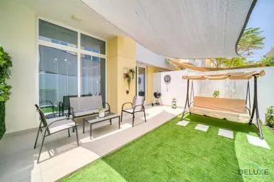 a patio with a hammock and a green yard at Magnificent 3BR Townhouse at DAMAC Hills 2, Dubailand by Deluxe Holiday Homes in Dubai