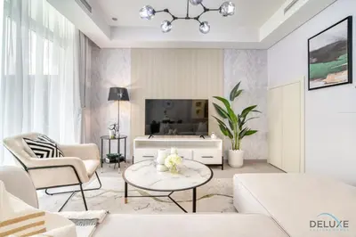 a living room with a couch and a tv at Magnificent 3BR Townhouse at DAMAC Hills 2, Dubailand by Deluxe Holiday Homes in Dubai
