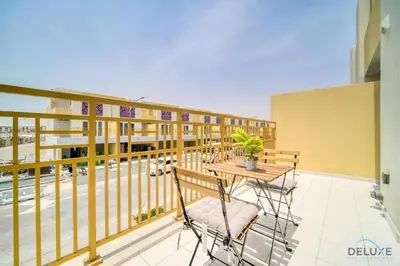 a balcony with a table and chairs on a building at Magnificent 3BR Townhouse at DAMAC Hills 2, Dubailand by Deluxe Holiday Homes in Dubai