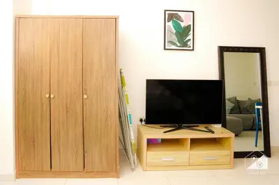 a living room with a television and a wooden cabinet at Stunning Palm Views Apt on the beach Dubai in Dubai