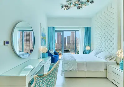 a white bedroom with a large bed and a mirror at FIRST CLASS 2BD, Full Burj Khalifa view in the Heart of Downtown in Dubai