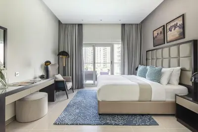 a bedroom with a large bed and a desk and a room at Frank Porter - Majestine 1 in Dubai