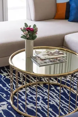 a glass coffee table with a vase with flowers on it at Frank Porter - Majestine 1 in Dubai