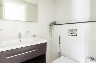 a white bathroom with a sink and a toilet at Frank Porter - Majestine 1 in Dubai