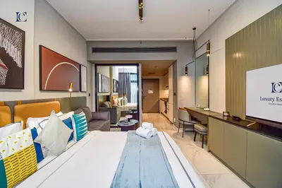 a hotel room with a bed and a living room at Luxury Escapes - Large & Brand New Studio Apt Business Bay - MAG in Dubai