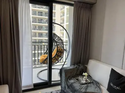 a room with a balcony with a chair and a window at Quasi-Hotels Zada Cozy Lux in Business Bay 1BR in Dubai