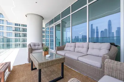 a living room with a couch and a table at Elegant seaside living 3-bedroom Emaar Beachfront by Suiteable in Dubai