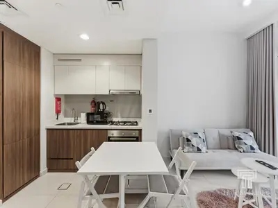 a kitchen and living room with a white table and chairs at Cozy 1 BR in Business Bay Dubai by GP Holiday Homes in Dubai