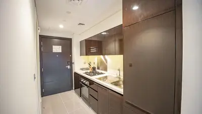 a kitchen with brown cabinets and a sink and a stove at Luxurious Studio in Business Bay by Tanami Holiday Homes in Dubai