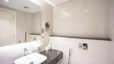 a white bathroom with a sink and a mirror at Luxurious Studio in Business Bay by Tanami Holiday Homes in Dubai