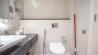 a white bathroom with a toilet and a sink at Luxurious Studio in Business Bay by Tanami Holiday Homes in Dubai
