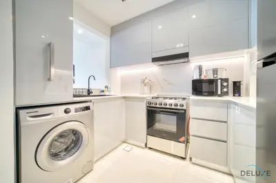 a white kitchen with a washer and a dishwasher at Pristine 1BR at Binghatti Creek Al Jadaf by Deluxe Holiday Homes in Dubai