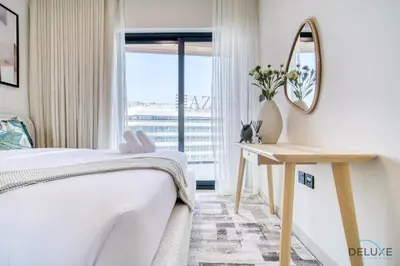 a bedroom with a bed and a mirror and a window at Pristine 1BR at Binghatti Creek Al Jadaf by Deluxe Holiday Homes in Dubai