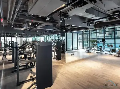 a gym with treadmills and exercise equipment in a building at Pristine 1BR at Binghatti Creek Al Jadaf by Deluxe Holiday Homes in Dubai