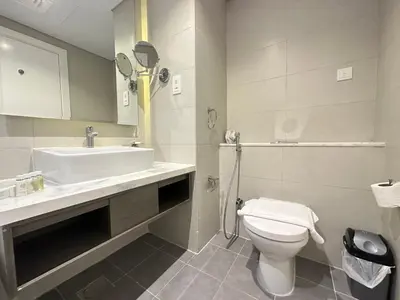 a bathroom with a sink and a toilet and a mirror at Business Bay Modern studio with a Canal view at DAMAC Maison Prive 1616 in Dubai