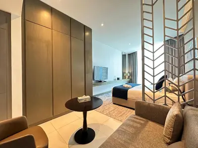a hotel room with a bed and a couch and a table at Business Bay Modern studio with a Canal view at DAMAC Maison Prive 1616 in Dubai